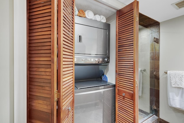 washroom featuring a textured ceiling and stacked washer and clothes dryer