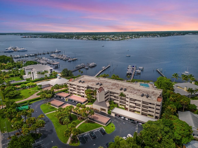 aerial view at dusk featuring a water view