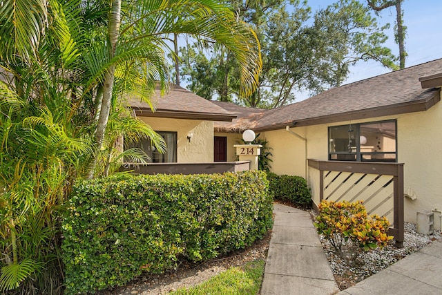 view of front of home with a shingled roof and stucco siding