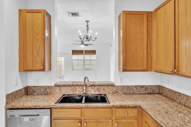 kitchen featuring stainless steel dishwasher, pendant lighting, ceiling fan with notable chandelier, light stone counters, and sink