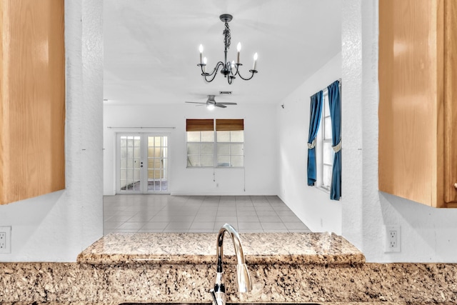 kitchen with ceiling fan with notable chandelier, french doors, and light tile patterned flooring