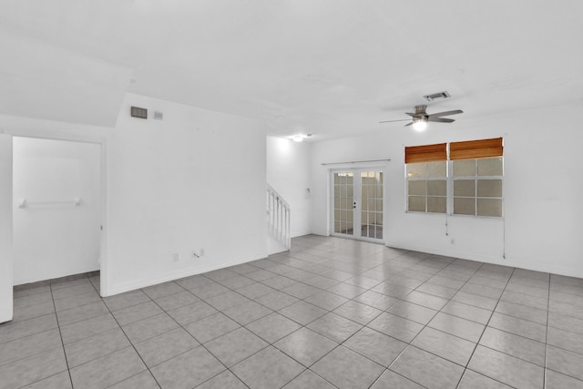 tiled empty room with ceiling fan and french doors