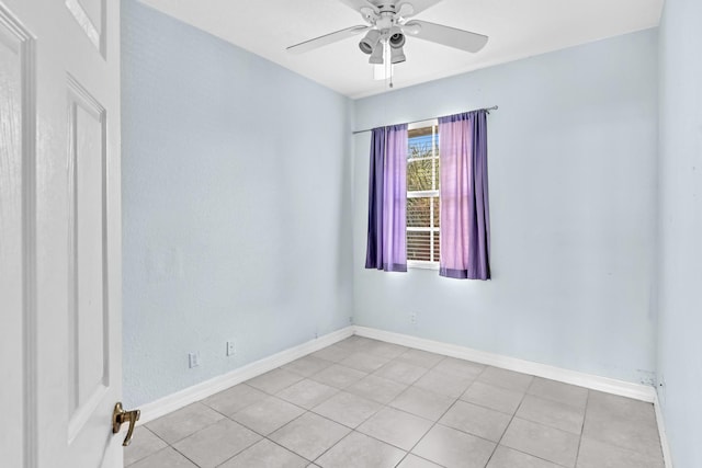 spare room with ceiling fan and light tile patterned floors