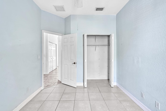 unfurnished bedroom featuring light tile patterned floors, a closet, and ceiling fan