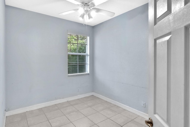 tiled empty room featuring ceiling fan