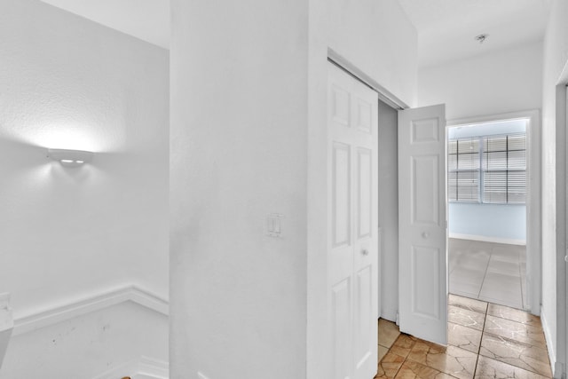 hall with light tile patterned floors