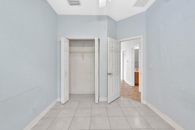 unfurnished bedroom featuring light tile patterned floors, a closet, and ceiling fan