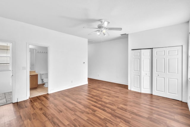 unfurnished bedroom featuring connected bathroom, ceiling fan, and light wood-type flooring