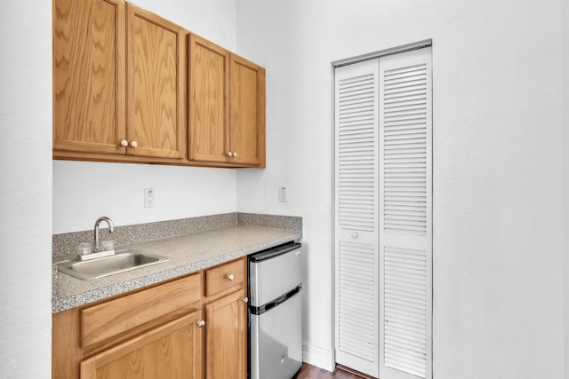 kitchen with sink, fridge, and dark hardwood / wood-style flooring