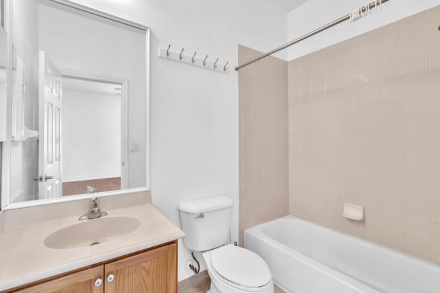 full bathroom with tiled shower / bath, toilet, and vanity