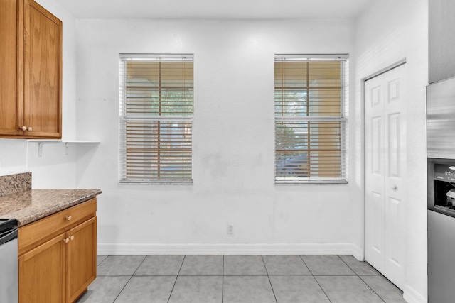 kitchen with light tile patterned floors and light stone counters