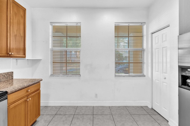 kitchen with light tile patterned floors and light stone countertops