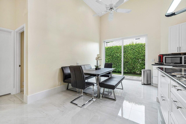 dining area with ceiling fan and high vaulted ceiling