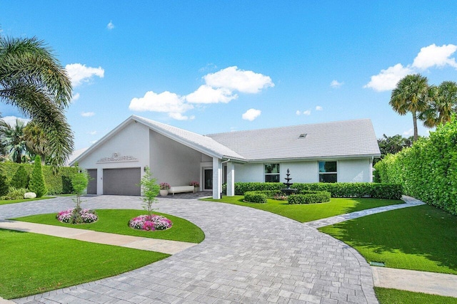 single story home featuring a garage and a front lawn