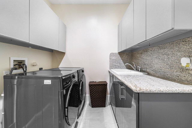 laundry room with separate washer and dryer, sink, light tile patterned floors, and cabinets