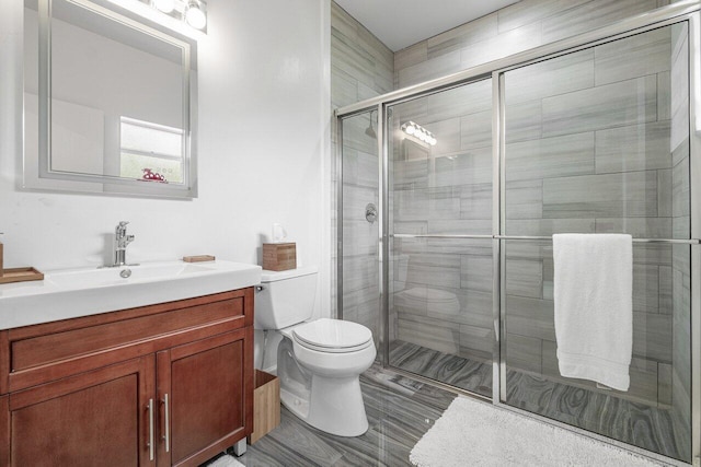 bathroom with vanity, toilet, and an enclosed shower