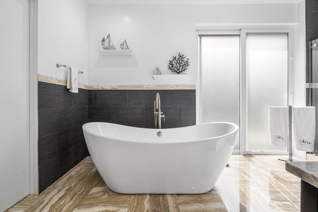 bathroom featuring a bathtub and tile walls