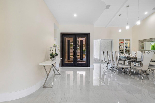 dining room featuring french doors, beamed ceiling, plenty of natural light, and a high ceiling