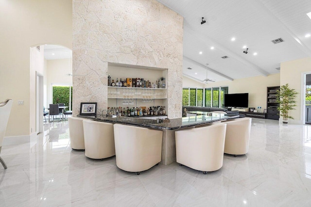 interior space featuring wooden ceiling, high vaulted ceiling, beamed ceiling, and ceiling fan