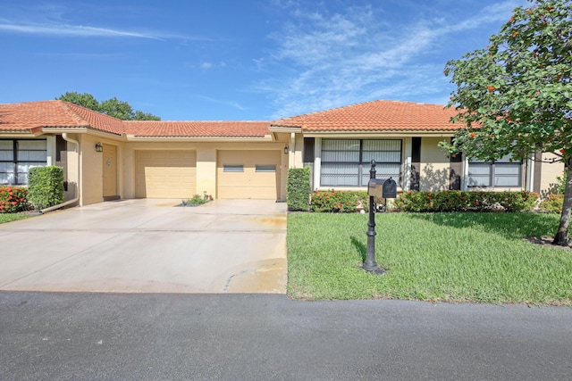 view of front of property with a tile roof, stucco siding, a garage, driveway, and a front lawn