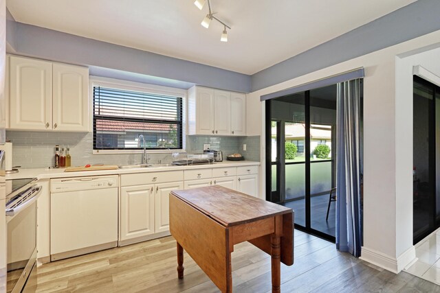 kitchen with white cabinets, dishwasher, stainless steel stove, and a wealth of natural light