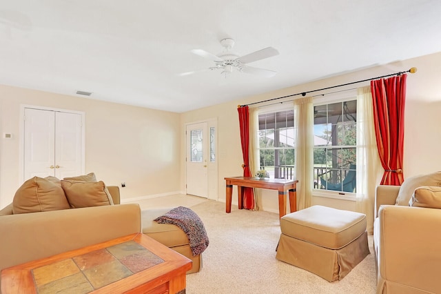 carpeted living room with ceiling fan