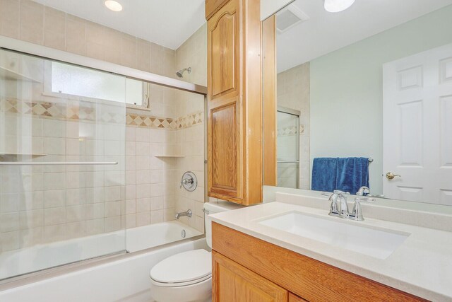 full bathroom with vanity, combined bath / shower with glass door, and toilet