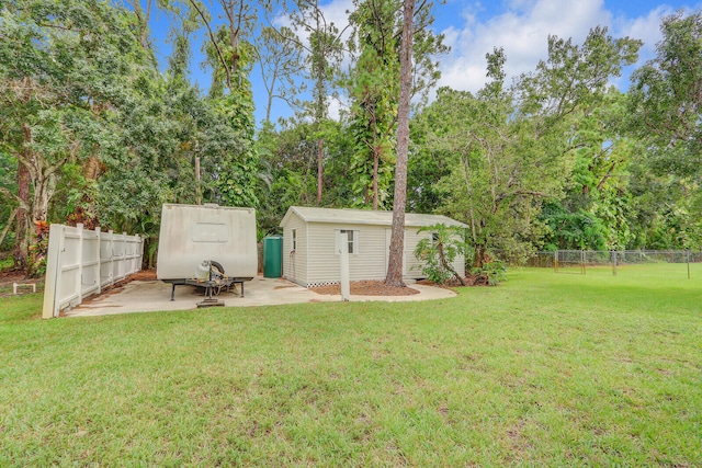 view of yard featuring a storage unit and a patio area