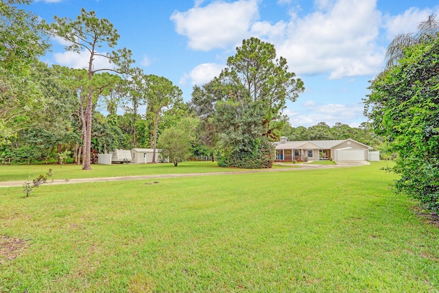 view of yard featuring a garage and an outdoor structure