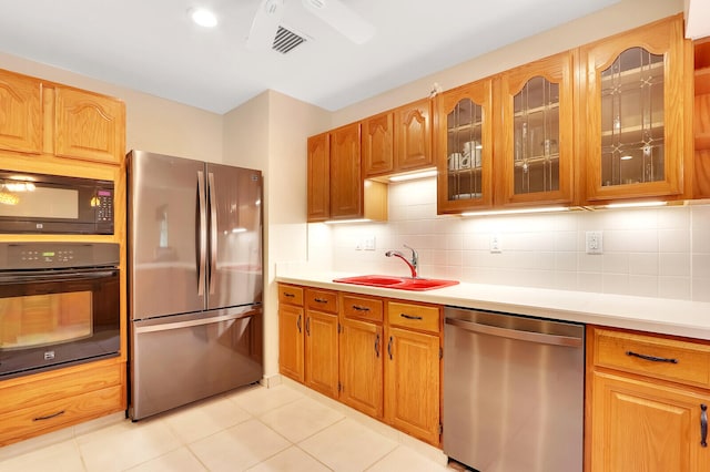 kitchen with sink, light tile patterned floors, black appliances, and decorative backsplash