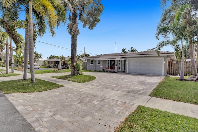 single story home featuring a garage and a front yard