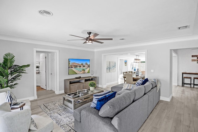 living room with light hardwood / wood-style floors and ceiling fan