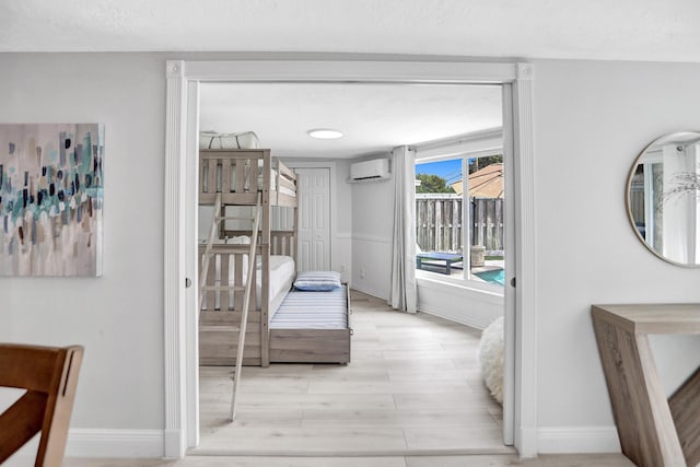 hall with wood-type flooring, a wall mounted air conditioner, and a textured ceiling