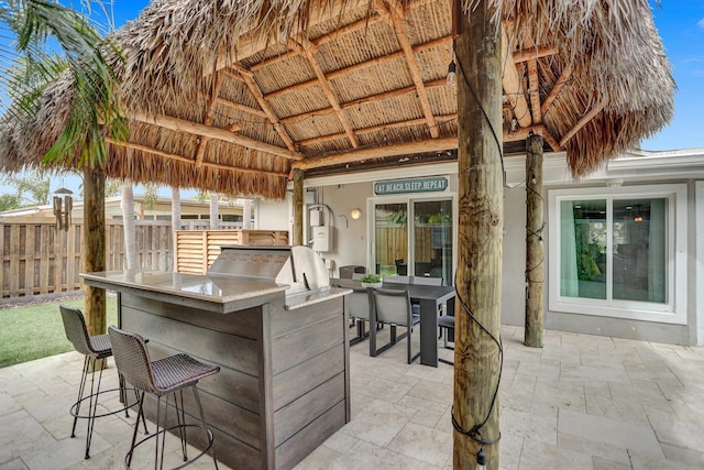 view of patio / terrace with a bar and an outdoor kitchen