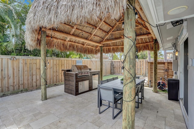 view of patio featuring exterior kitchen, a gazebo, and a grill