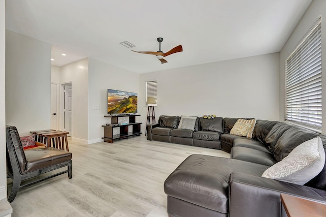 living room with light hardwood / wood-style flooring and ceiling fan