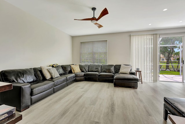 living room with light hardwood / wood-style floors and ceiling fan