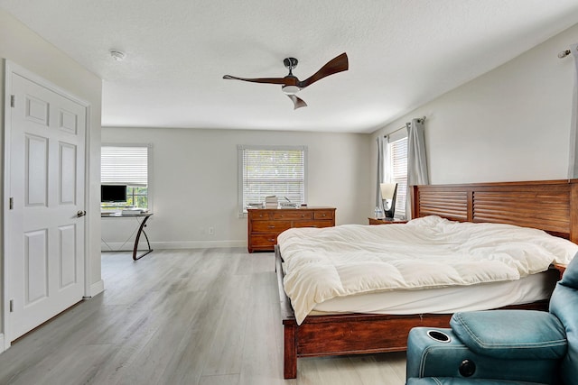 bedroom with multiple windows, light wood-type flooring, and ceiling fan