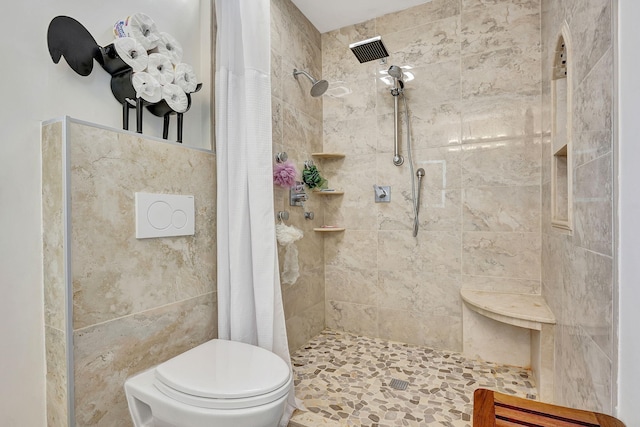 bathroom featuring toilet, a shower with curtain, and tile walls