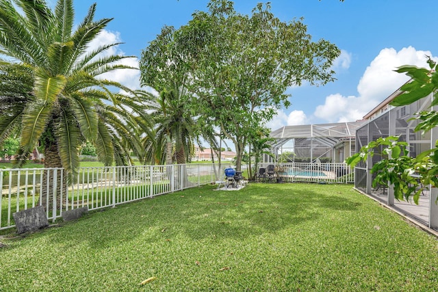 view of yard featuring a fenced in pool and glass enclosure