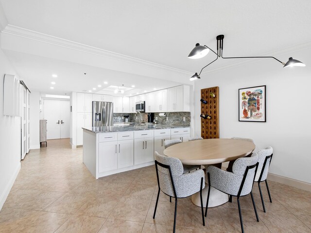 kitchen with sink, stainless steel appliances, a raised ceiling, and kitchen peninsula