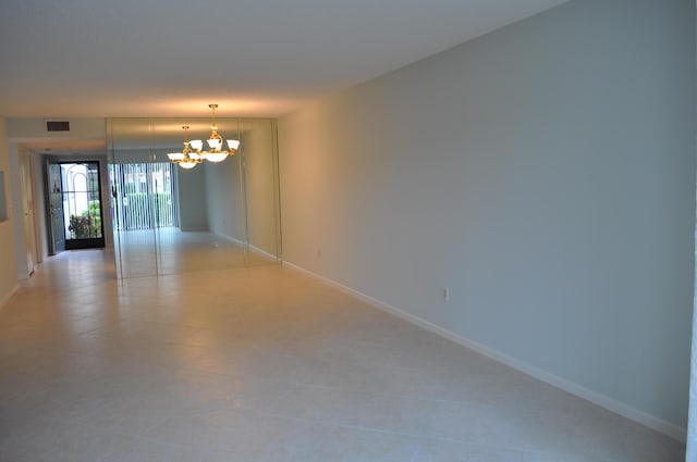 unfurnished room with a notable chandelier