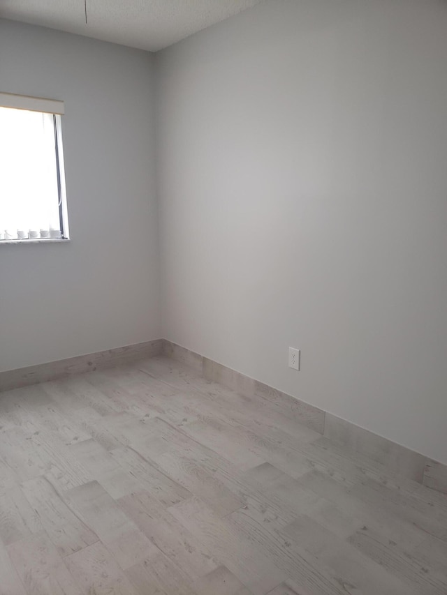 spare room with wood-type flooring