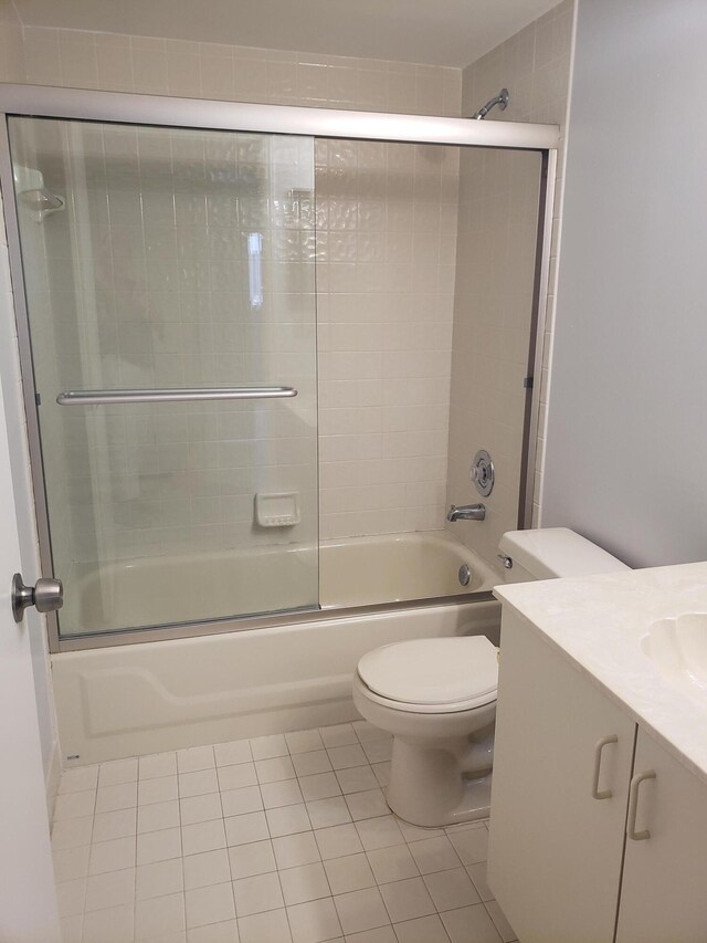 full bathroom featuring combined bath / shower with glass door, vanity, toilet, and tile patterned flooring