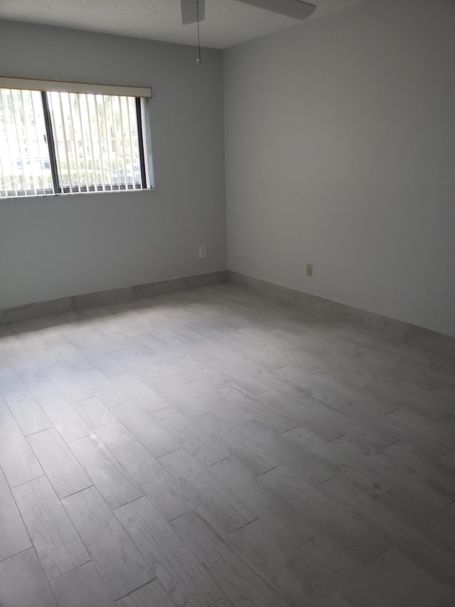 spare room featuring ceiling fan, a textured ceiling, and hardwood / wood-style flooring