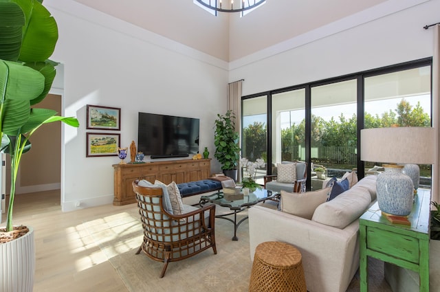 living room with light wood-type flooring and a high ceiling