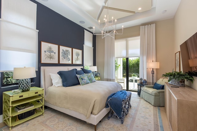 bedroom featuring a notable chandelier, access to exterior, and a towering ceiling