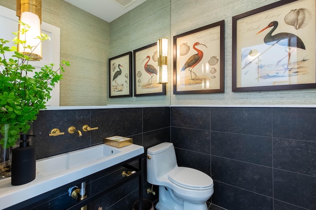 bathroom with tile patterned flooring, backsplash, toilet, vanity, and tile walls