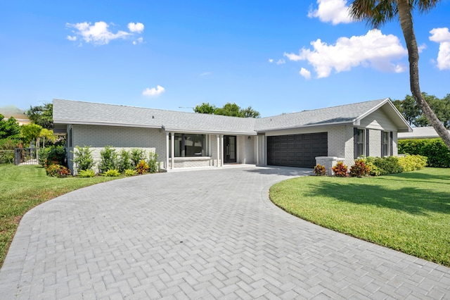 single story home featuring a front yard and a garage