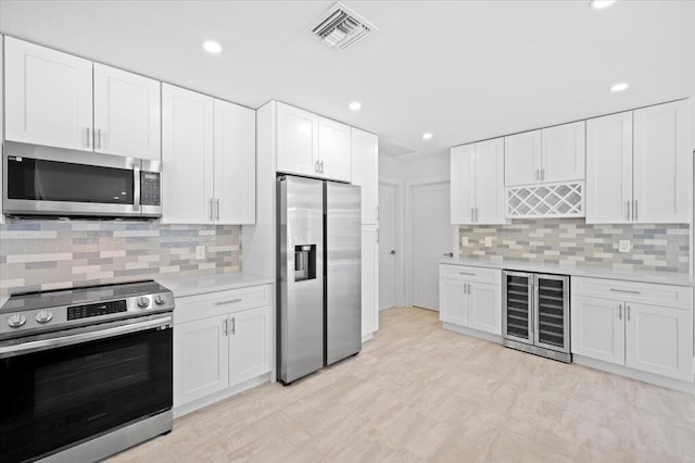 kitchen featuring wine cooler, white cabinetry, and appliances with stainless steel finishes